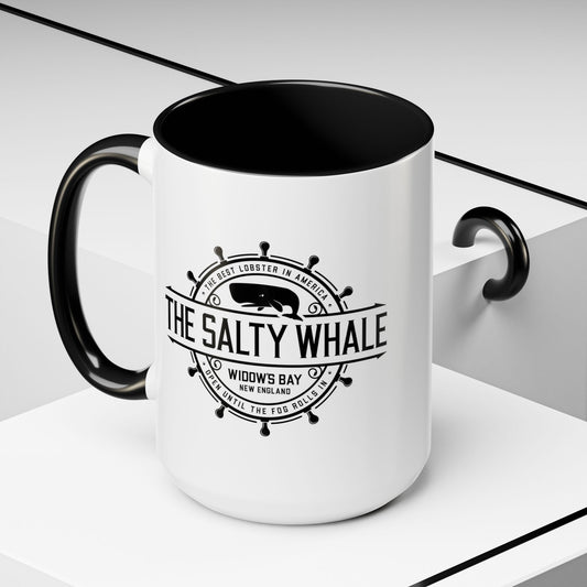 Angled view of 15 oz White ceramic mug with black handle and the vintage Salty Whale maritime crest logo from Widow's Bay TV show, New England