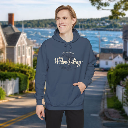 Person wearing Denim blue garment-dyed Widow's Bay hoodie with vintage island map design and Ask Me About Widow's Bay text