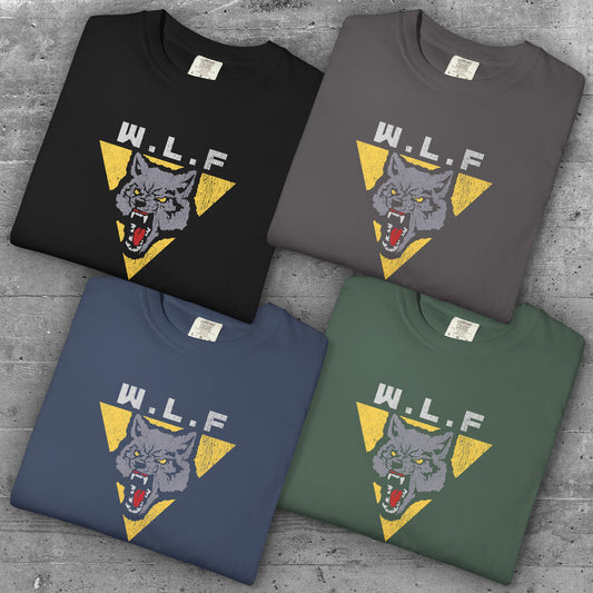 4 folded t-shirts with distressed WLF logo from The Last of Us, featuring a snarling wolf inside a yellow triangle.