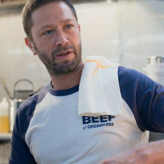 Scene from The Bear, Richie wearing Original Beef of Chicagoland raglan baseball t-shirt, white body with navy blue 3/4 sleeves and chest logo.