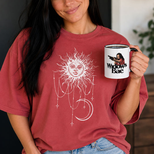 Person wearing Patricia tee and holding mug with a Widow's Bae Patricia illustration inspired by the Apple TV show Widow's Bay