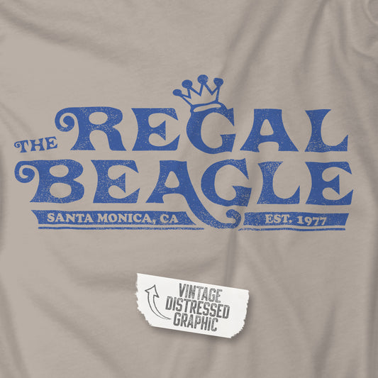 Closeup of sand beige Hanes EcoSmart pullover hoodie with vintage distressed Regal Beagle logo from Three’s Company on chest.