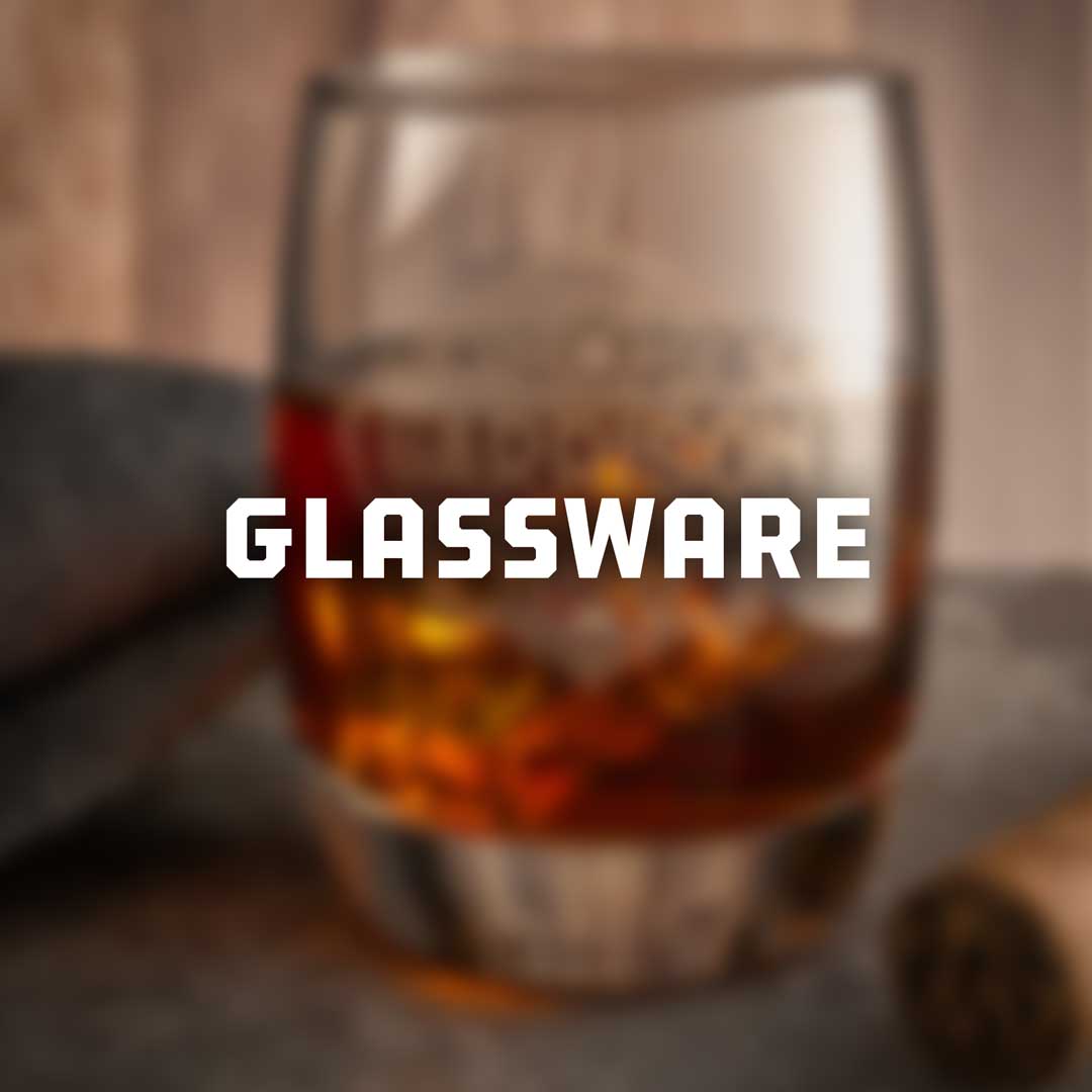 Glassware collection featuring a rocks glass filled with an amber drink and ice.