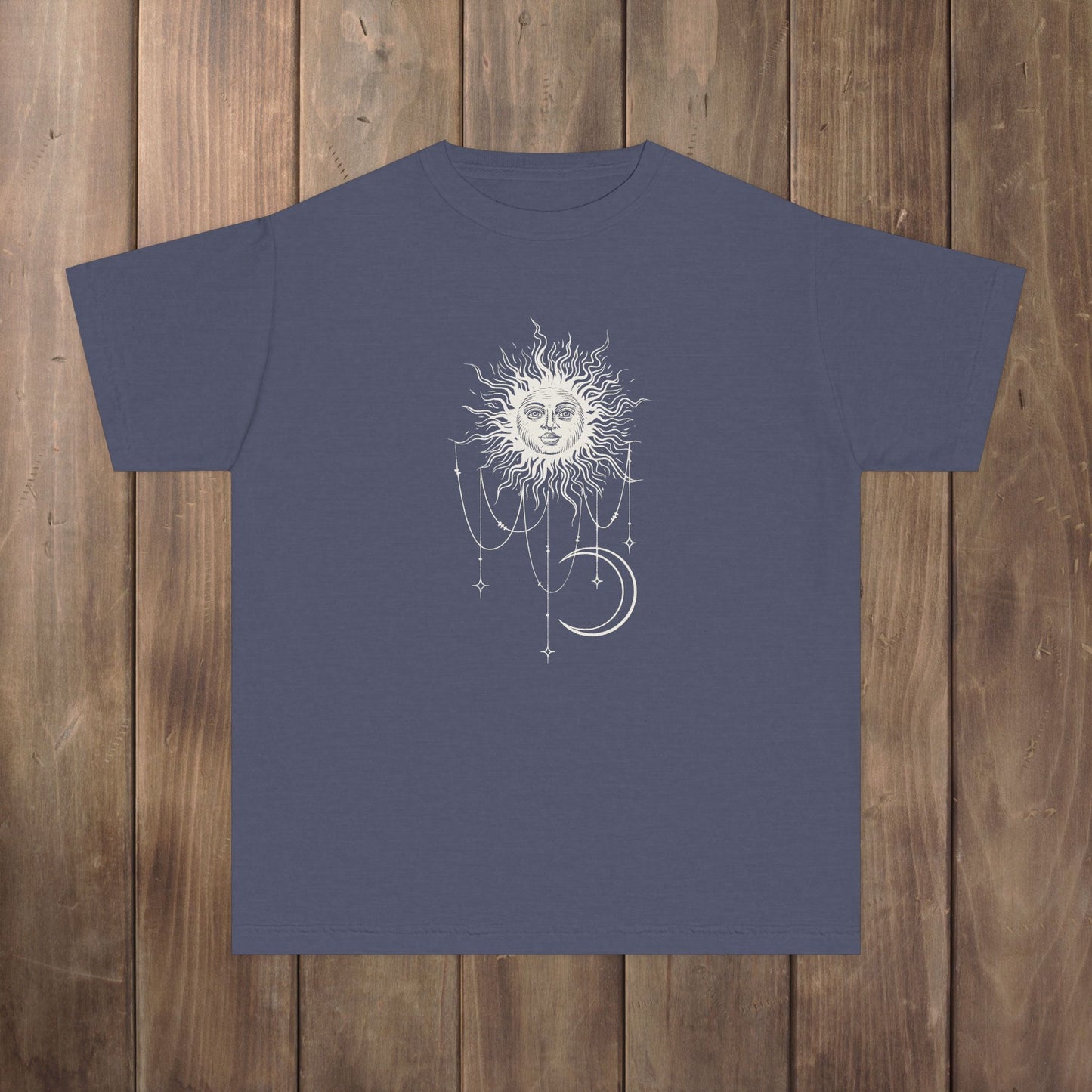 Front of denim blue youth tee with Patricia boho celestial sun, stars, and crescent moon design from Widow's Bay