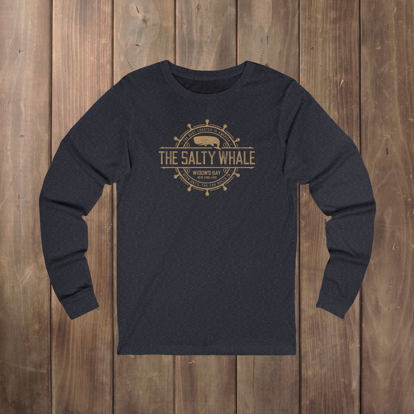 Heather navy long-sleeve tee with the gold distressed Salty Whale maritime crest logo from Widow's Bay, New England