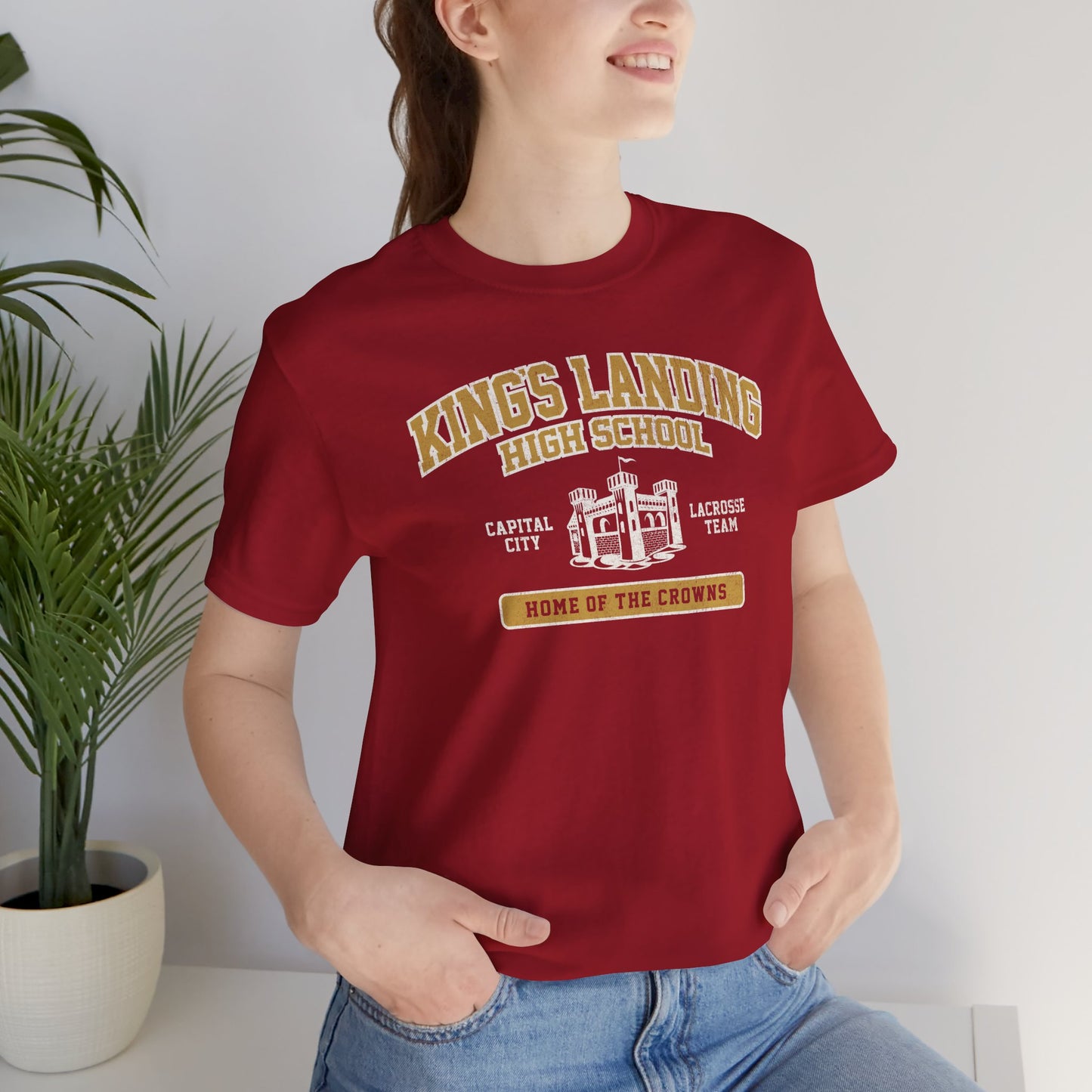 Woman wearing Red and Gold King's Landing High School t-shirt with vintage castle graphic inspired by Game of Thrones.
