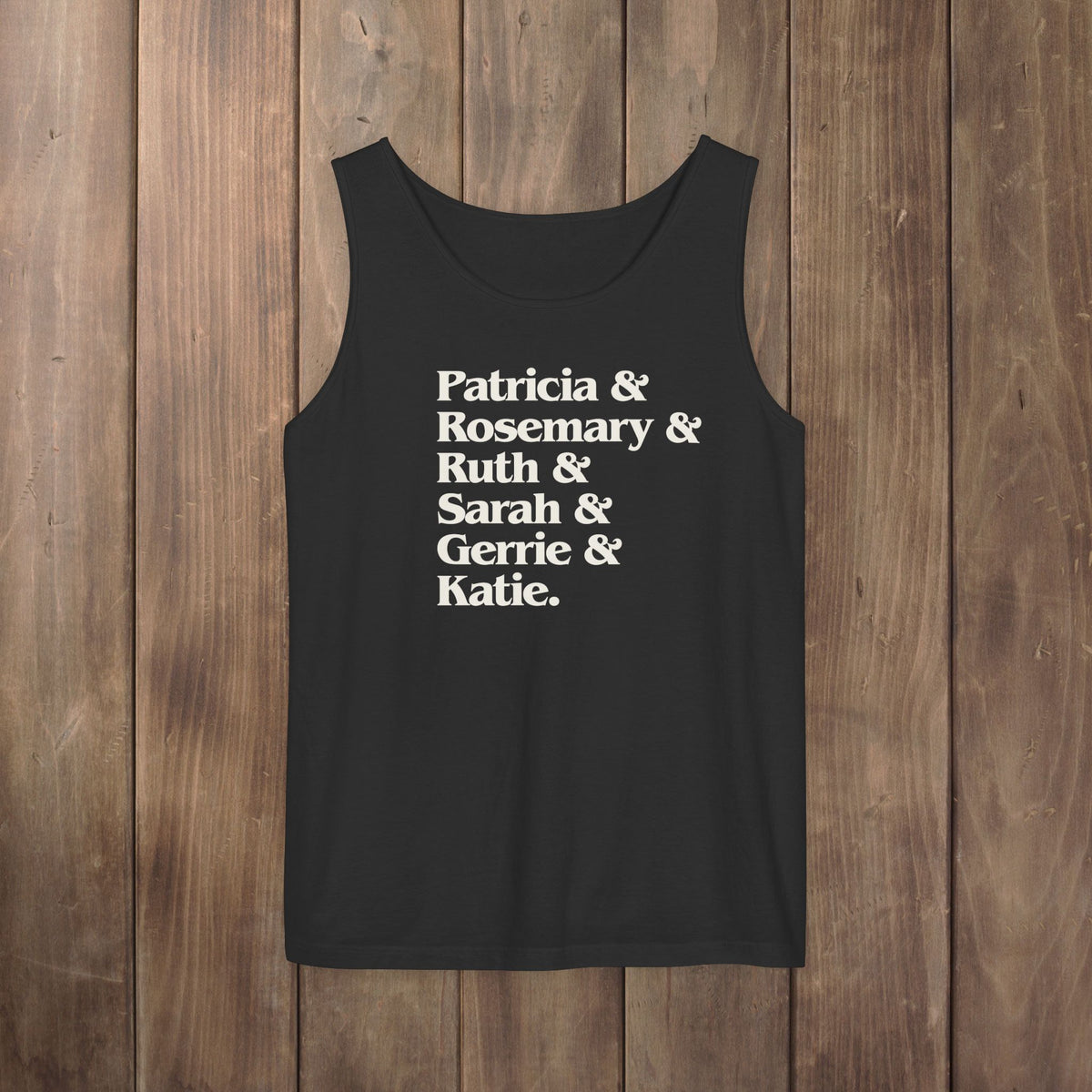 Black garment-dyed Comfort Colors tank top with stacked Women of Widow's Bay show names in ampersand list including Patricia, Ruth, Rosemary