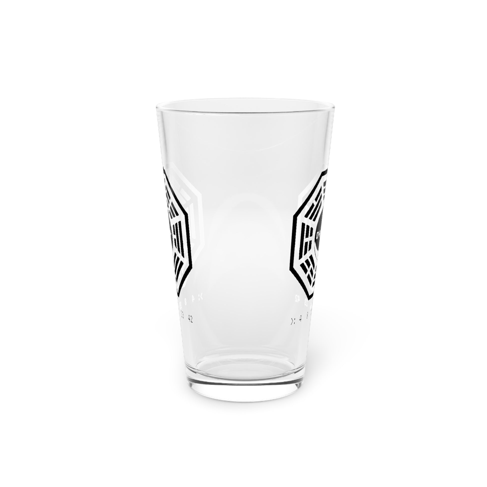 Side view of clear 16 oz pint glass with Dharma Initiative Swan Station logo and hatch numbers from Lost Show, on a kitchen table