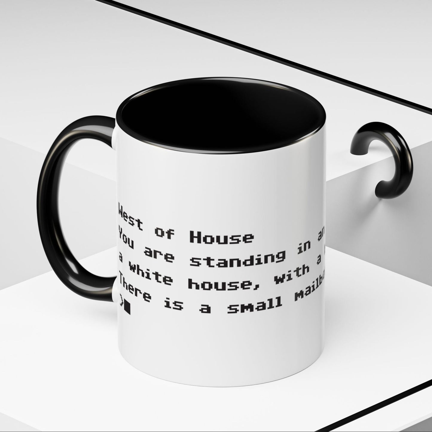 Angled view of 11 oz White ceramic accent mug with black handle and interior, Zork “West of House” opening line text wrapped in black print