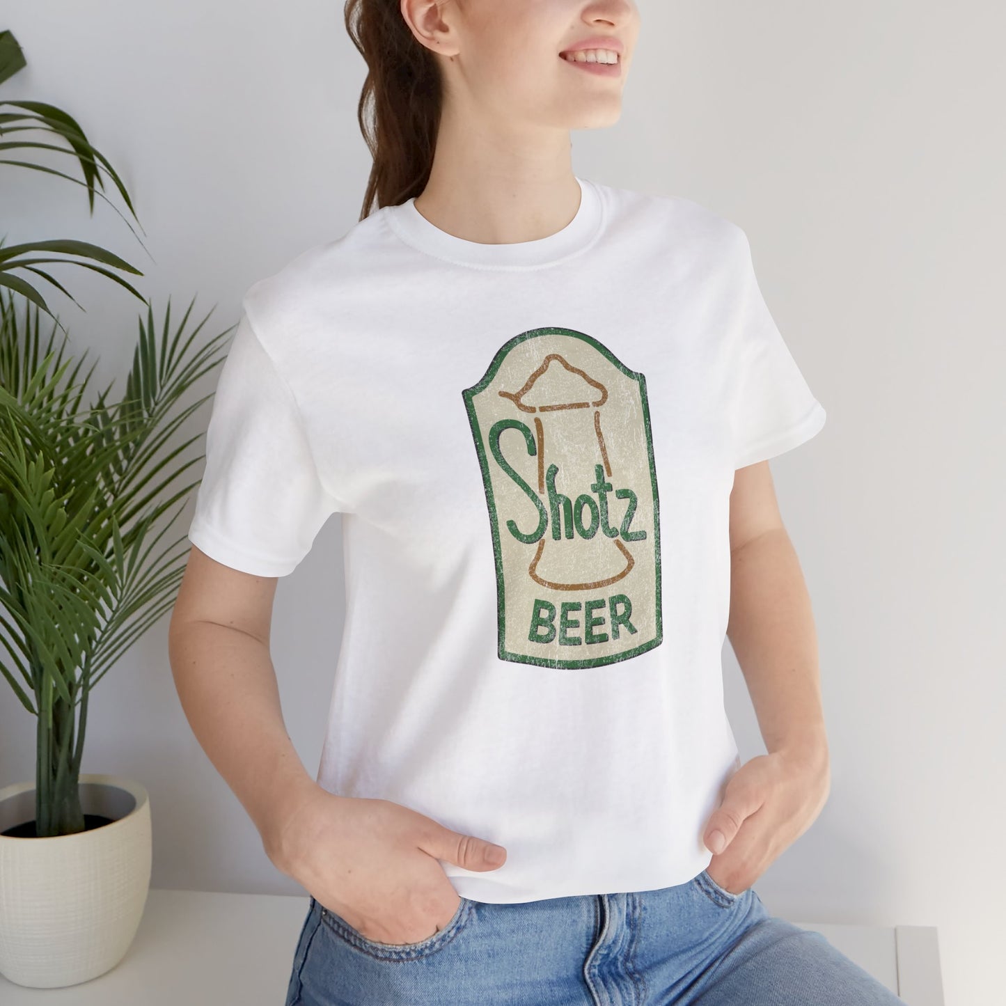 Model wearing white t-shirt with vintage Shotz Beer Brewery logo graphic, inspired by TV show Laverne & Shirley.