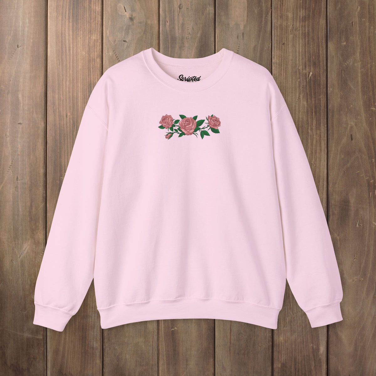 Light pink crewneck sweatshirt with three pink roses and green leaves printed across the chest, inspired by Ruth of Widow's Bay