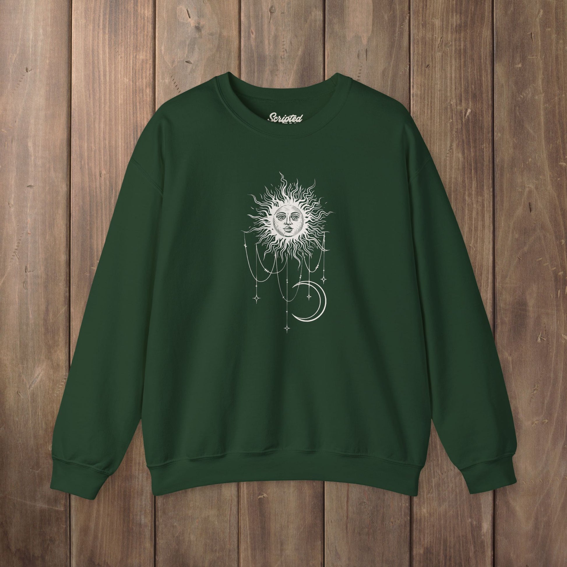 Forest green crewneck sweatshirt with boho celestial sun face, stars, and crescent moon design worn by Patricia in Widow's Bay