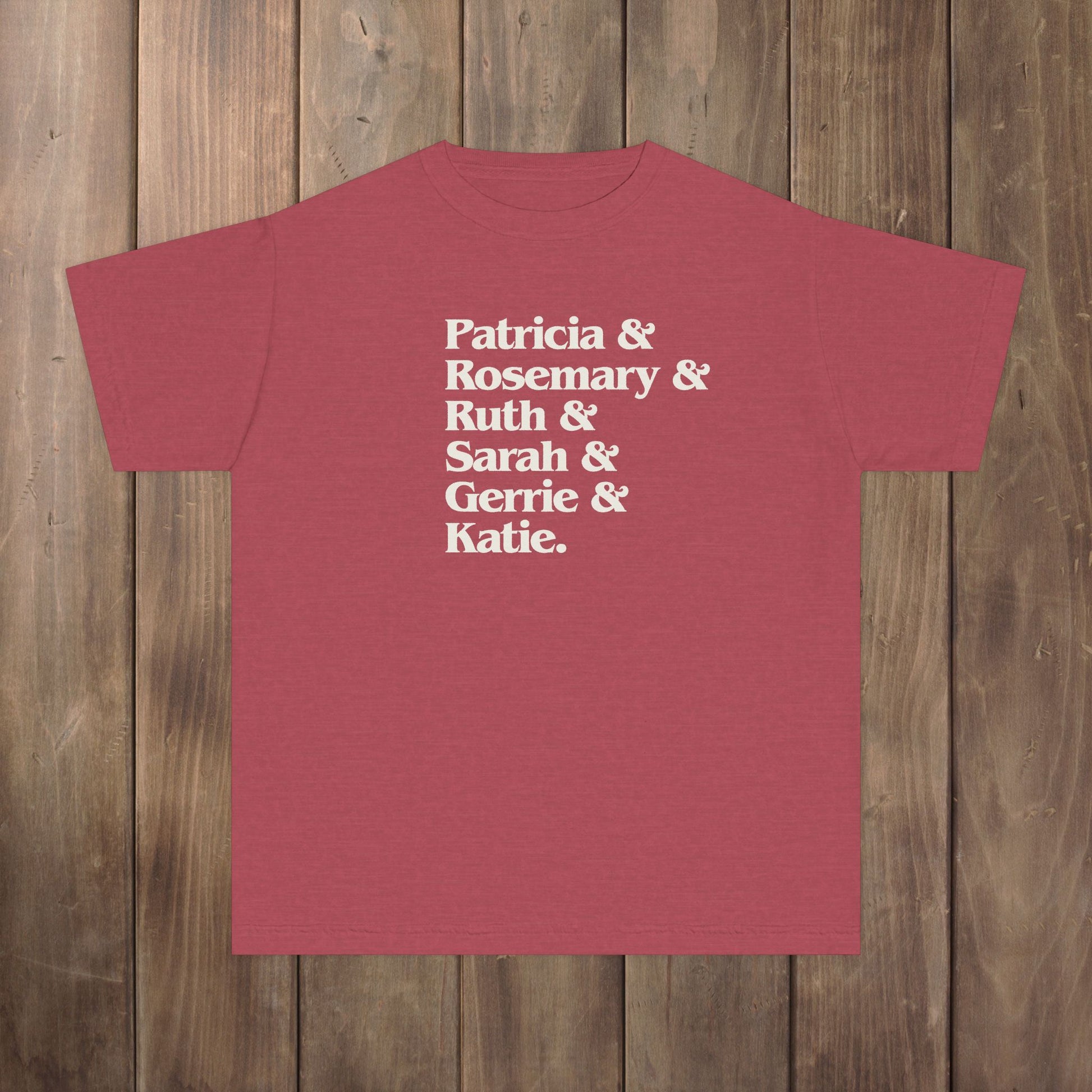 Crimson red youth kids tee with stacked Women of Widow's Bay names in cream type