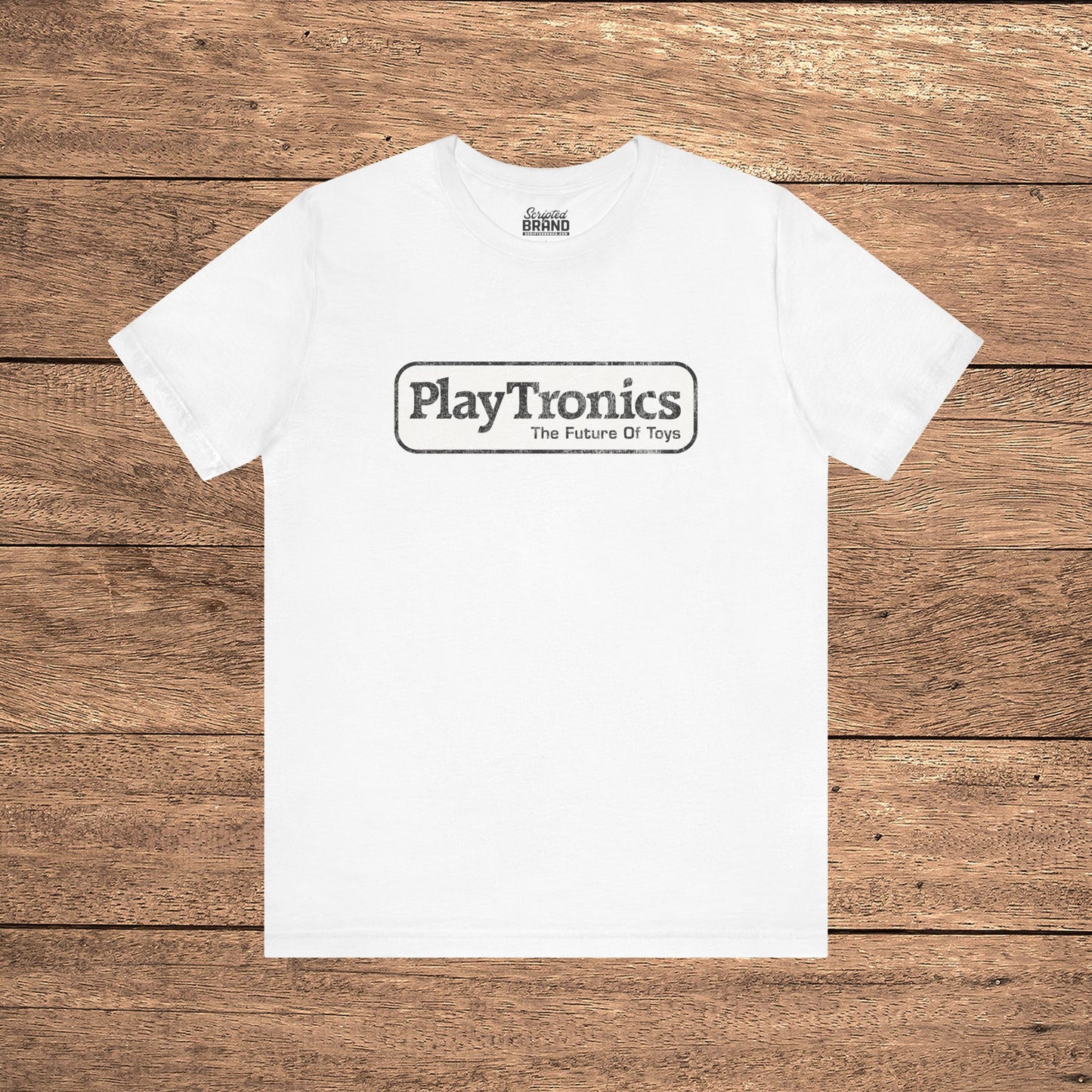 White PlayTronics Sneakers movie logo t-shirt on Bella+Canvas 3001, vintage distressed print, shown on wood floor.