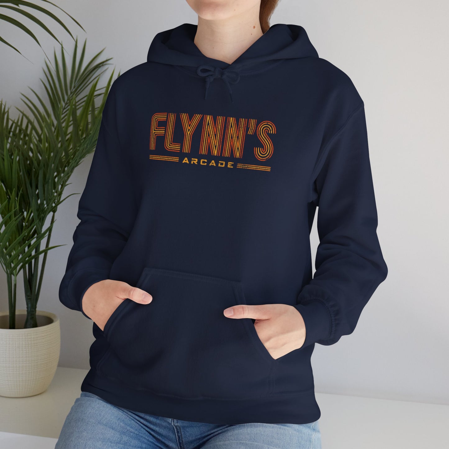 Woman wearing navy hoodie sweatshirt with vintage distressed 'Flynn’s Arcade' neon logo inspired by TRON