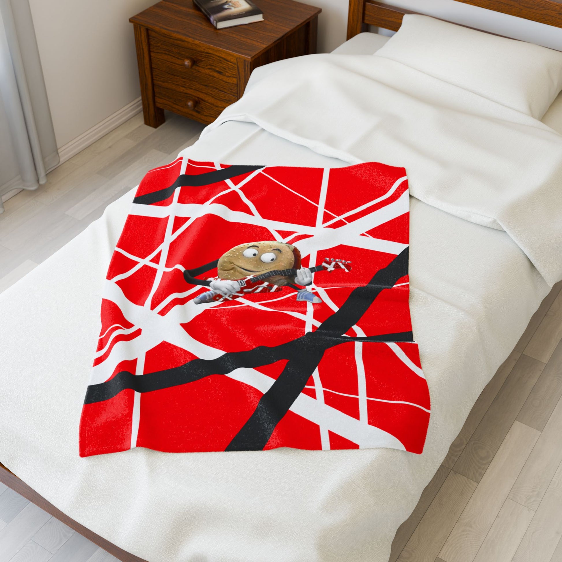 30x40 red, white, black Frankenstrat stripes plush blanket with singing hamburger guitar graphic, inspired by Better Off Dead and Van Halen, shown on bed.