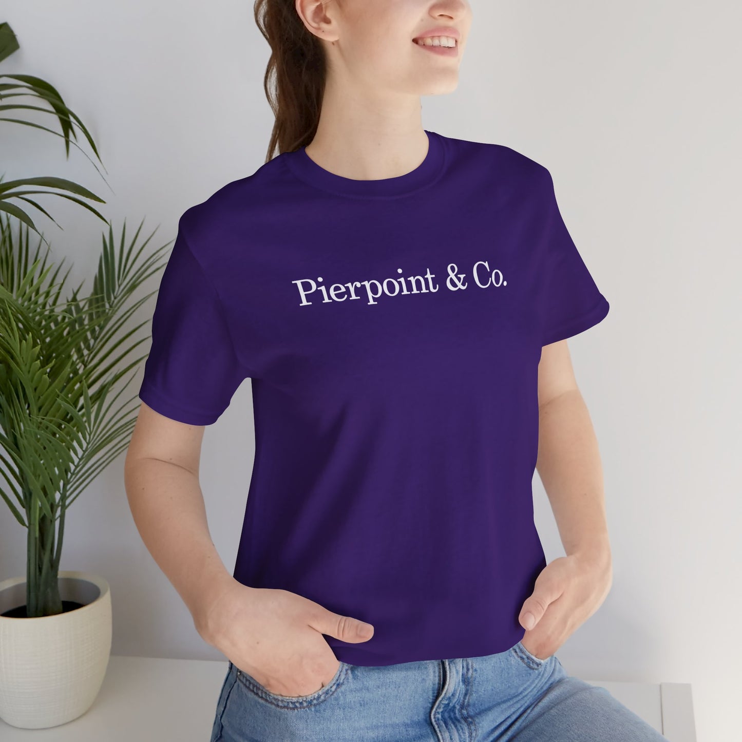 Woman wearing purple Pierpoint & Co. logo t-shirt inspired by HBO Industry TV series, soft Bella+Canvas cotton investment bank fan tee