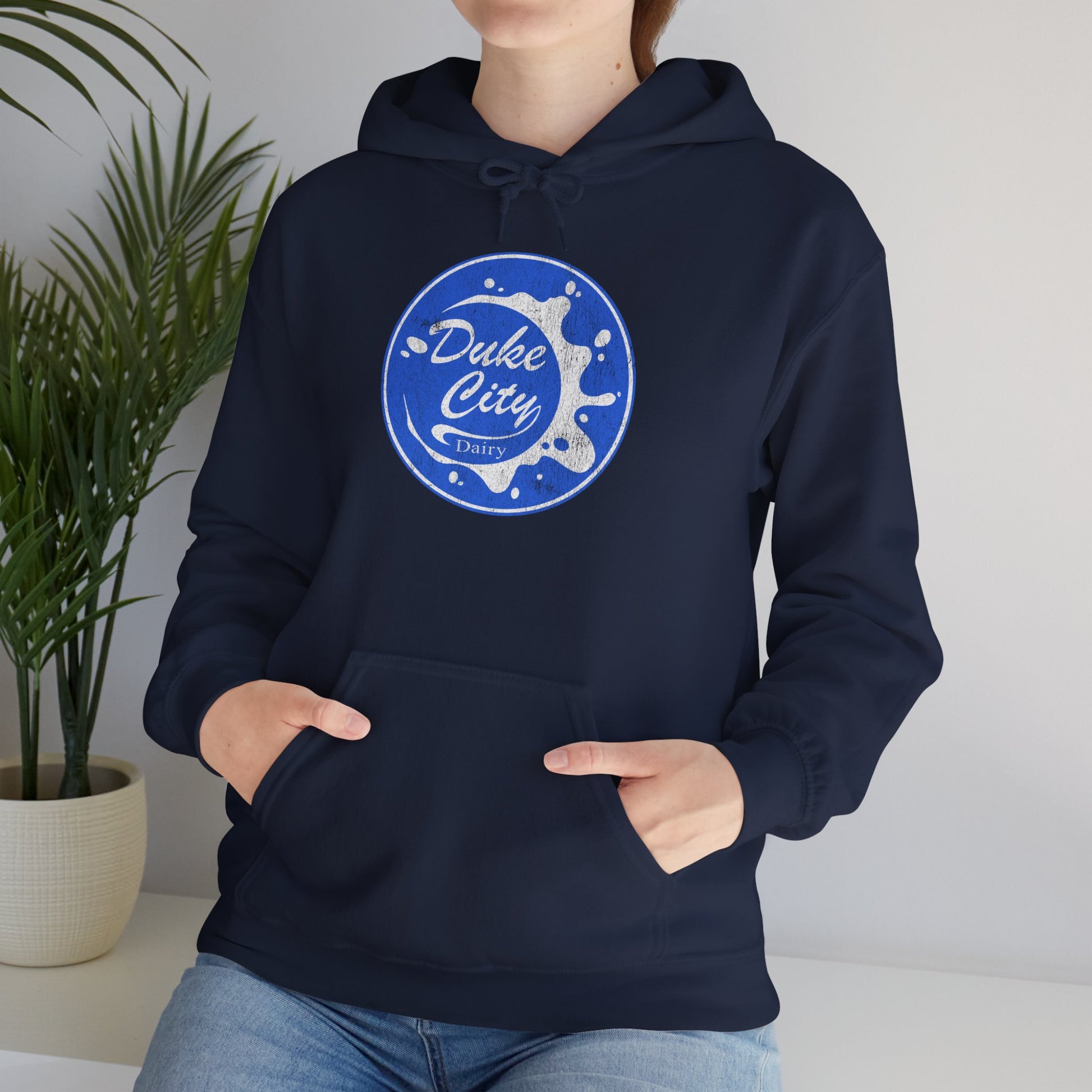 Woman wearing navy blue hoodie with 'Duke City Dairy' logo from Pluribus.