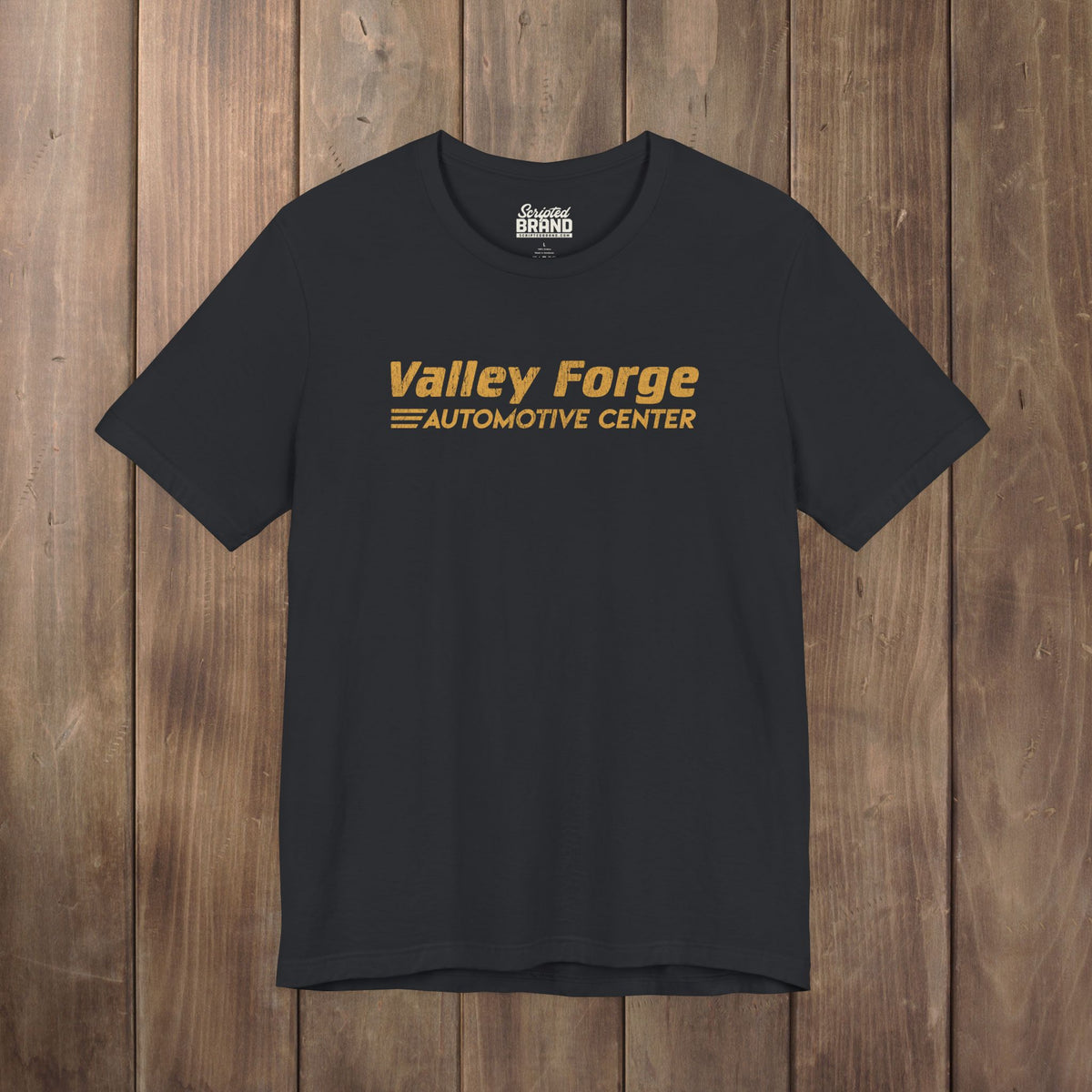 Black tee with vintage gold Valley Forge Automotive Center auto shop logo from comedian Shane Gillis Tires TV show