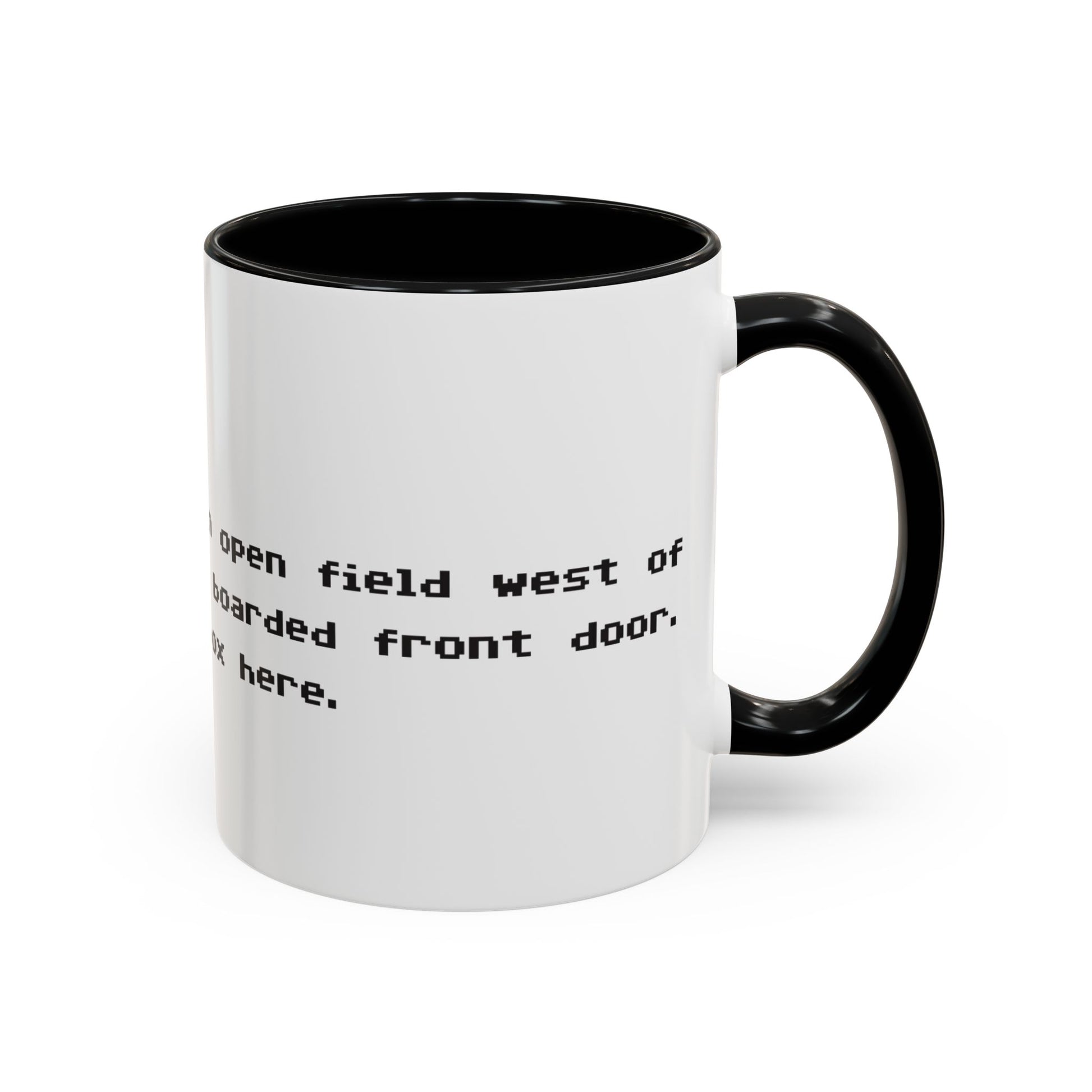 Right handle view of 11 oz White ceramic accent mug with black handle and interior, Zork “West of House” opening line text wrapped in black print