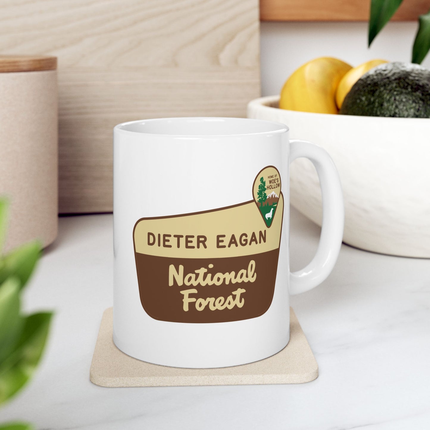 11 oz White ceramic mug with Dieter Eagan National Forest logo, inspired by Woe’s Hollow episode in Severance, shown in a kitchen.