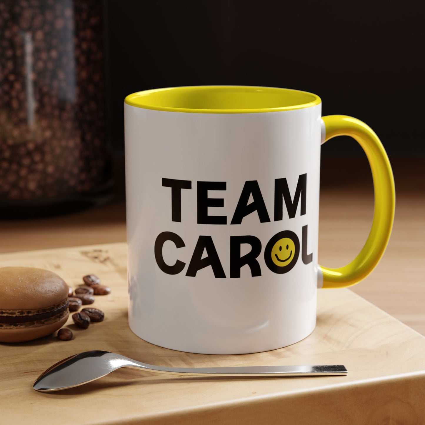 11 oz ceramic accent mug with yellow handle and interior, TEAM CAROL text and smiley face from Pluribus, shown in kitchen
