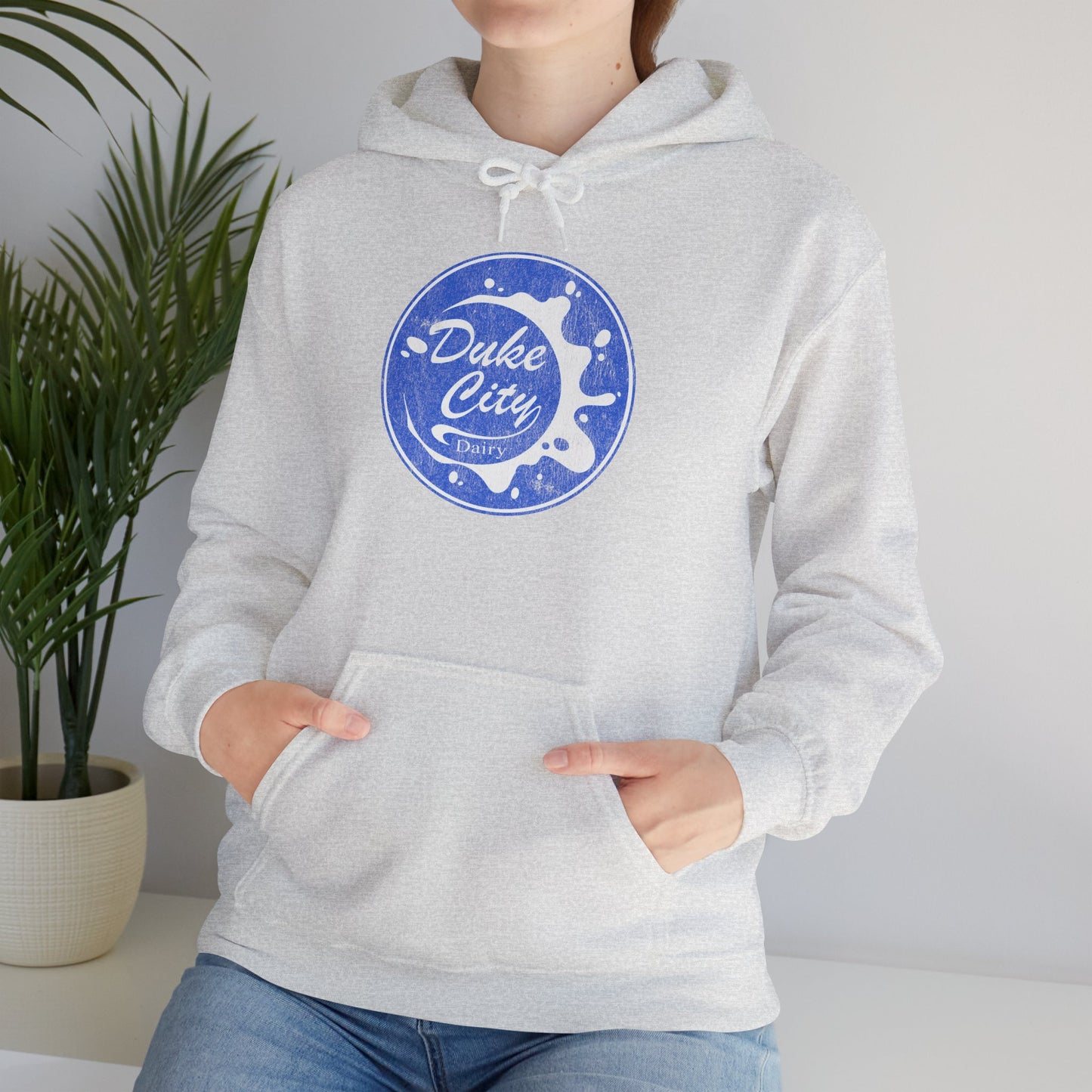 Woman wearing ash hoodie with 'Duke City Dairy' logo from Pluribus.