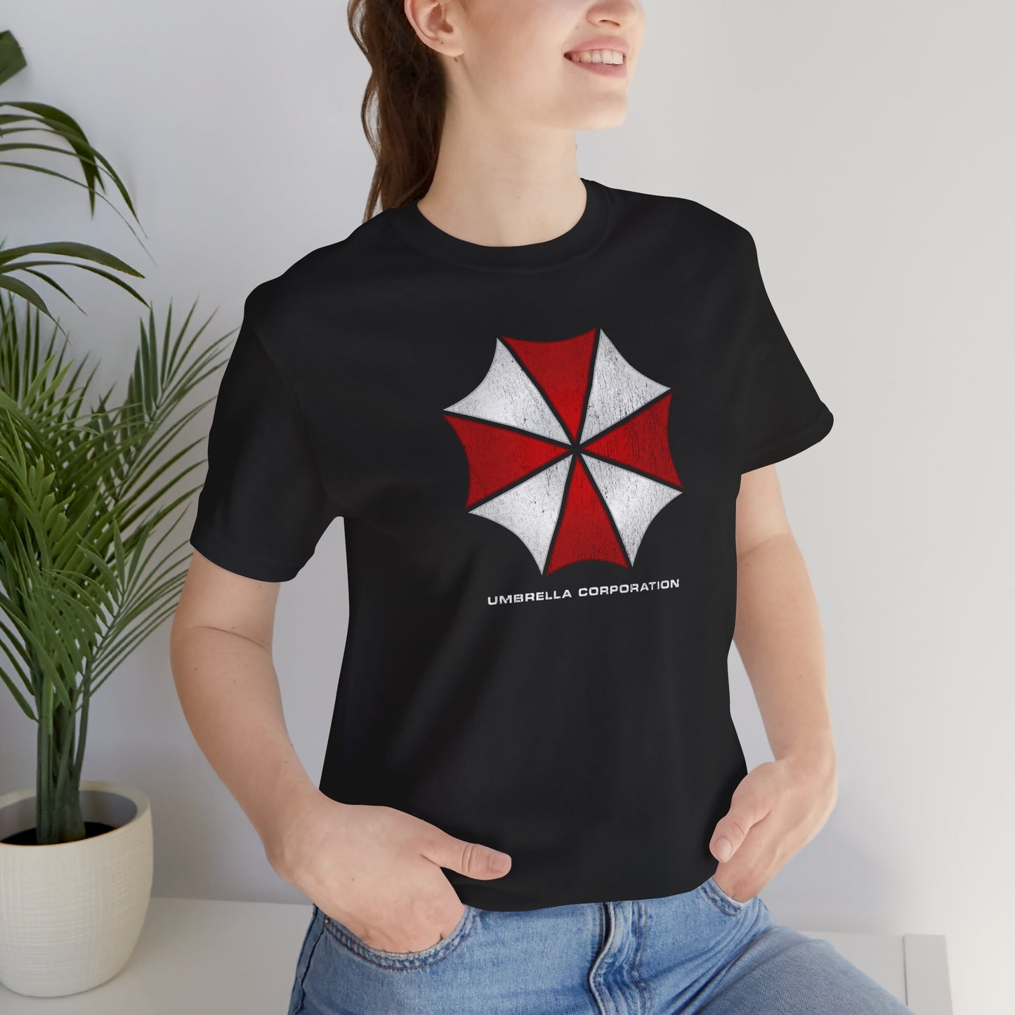 Woman wearing black t-shirt featuring the Umbrella Corp logo from the video game and movie franchise Resident Evil in a vintage distressed style.