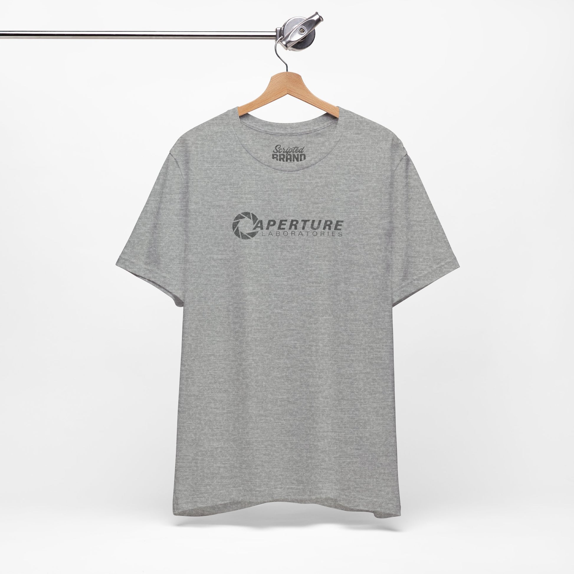 Athletic gray colored soft Bella+Canvas t-shirt on a hanger with the Aperture Laboratories logo from the video game Portal and Portal 2 in a vintage ink-stamped distressed style. 