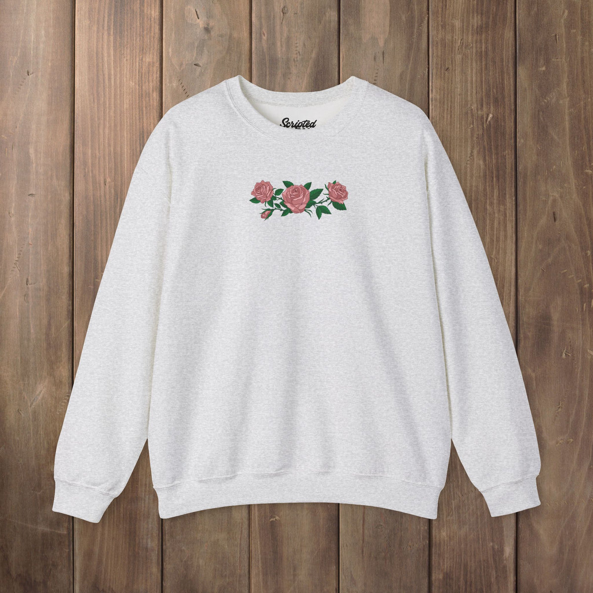 Ash crewneck sweatshirt with three pink roses and green leaves printed across the chest, inspired by Ruth of Widow's Bay