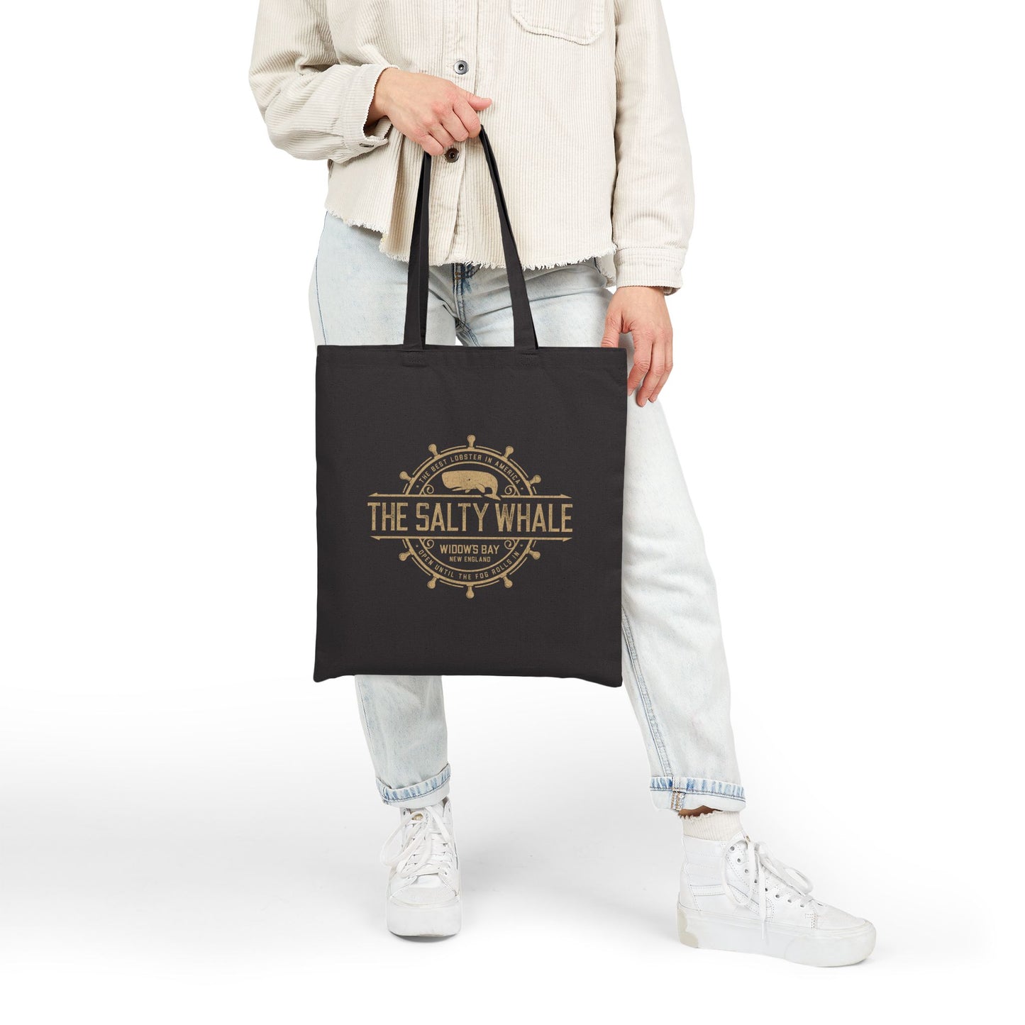Person holding black canvas tote bag with vintage The Salty Whale, Widow's Bay TV show nautical grocery shopping