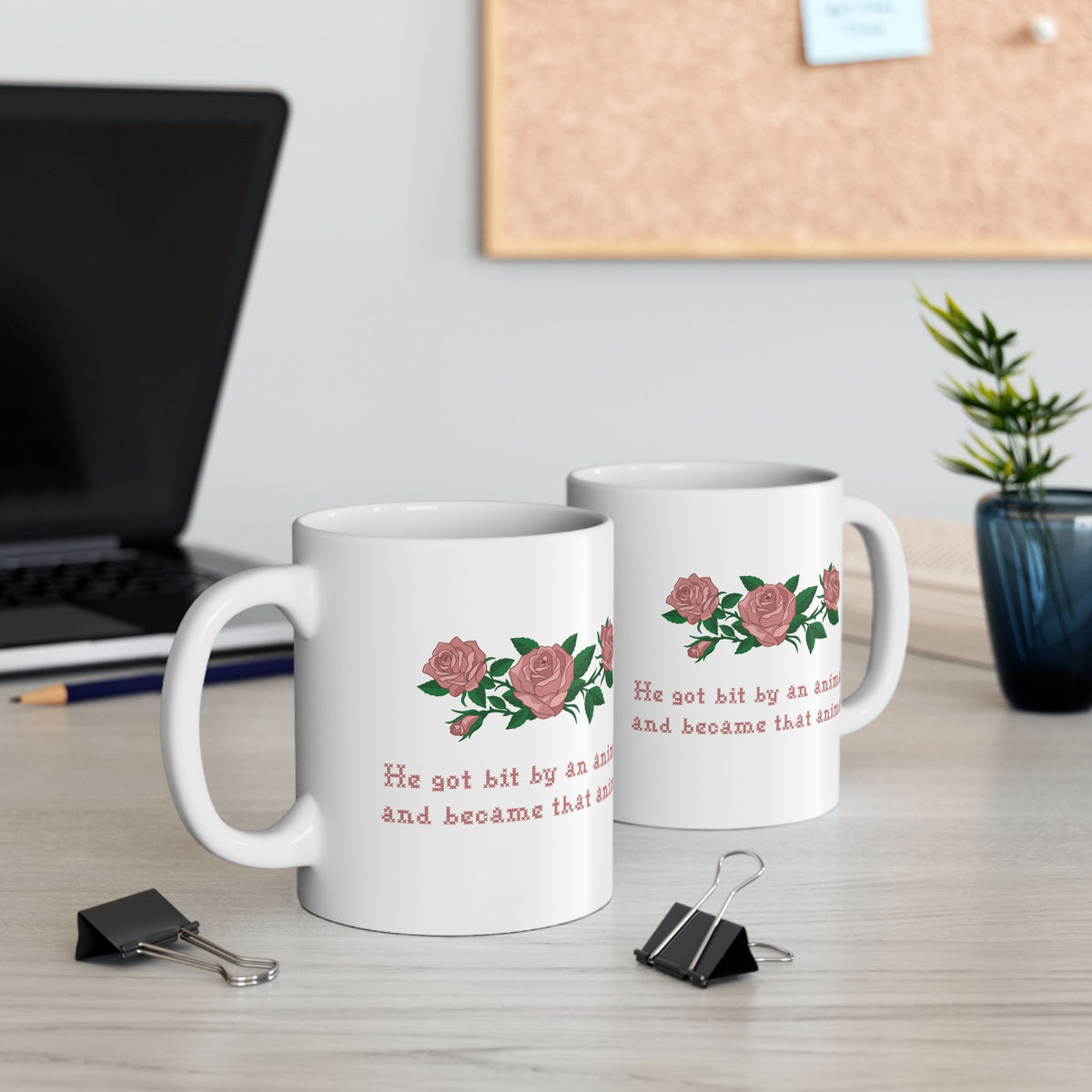 Two 11oz white ceramic mugs with a printed design of pink roses and green leaves, featuring the text 'He got bit by an animal, and became that animal' in cross stitch style, inspired by Ruth on Widows Bay