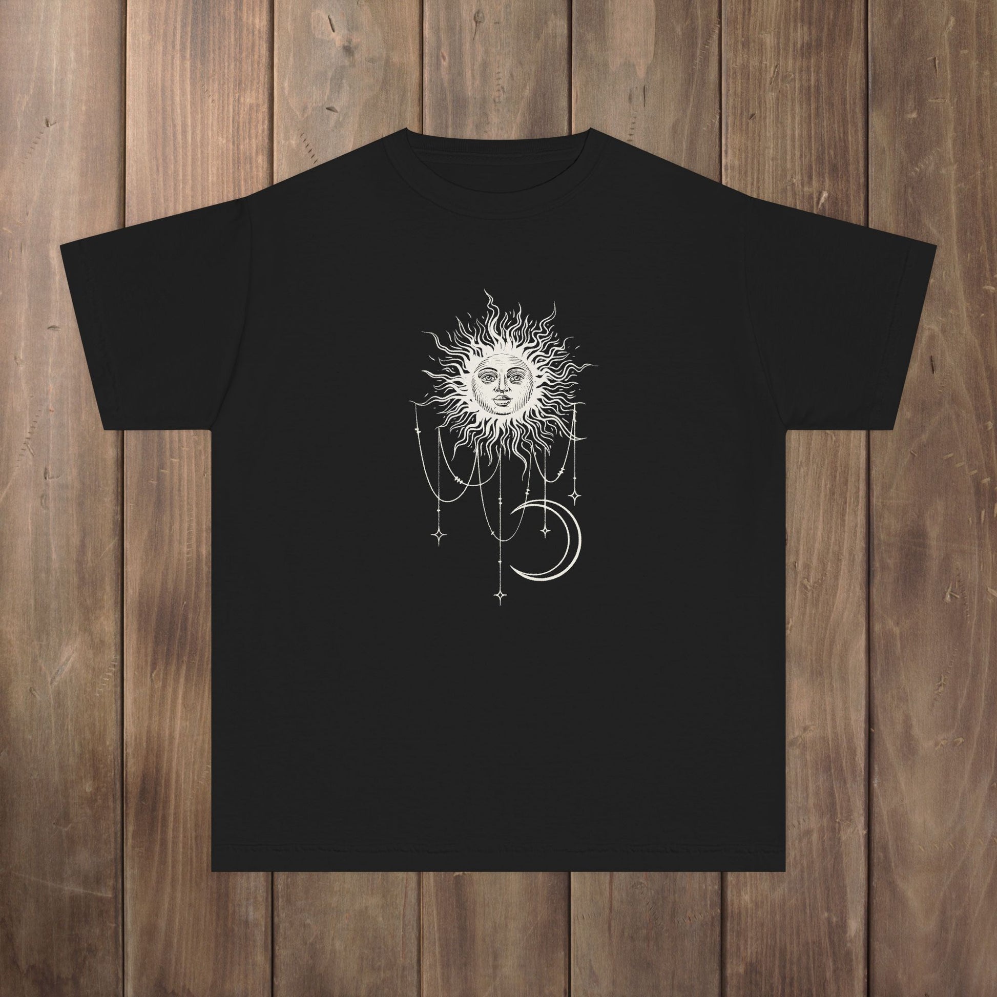 Front of black youth tee with Patricia boho celestial sun, stars, and crescent moon design from Widow's Bay