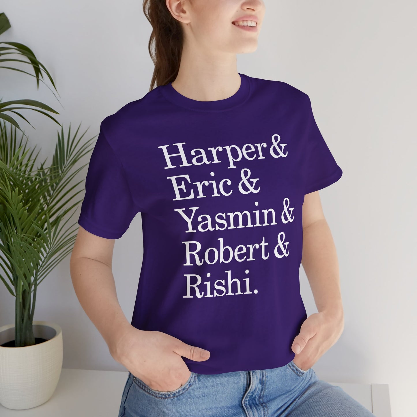 Woman wearing purple t-shirt with names Harper, Eric, Yasmin, Robert & Rishi in Pierpoint & Co. font, inspired by TV show Industry.