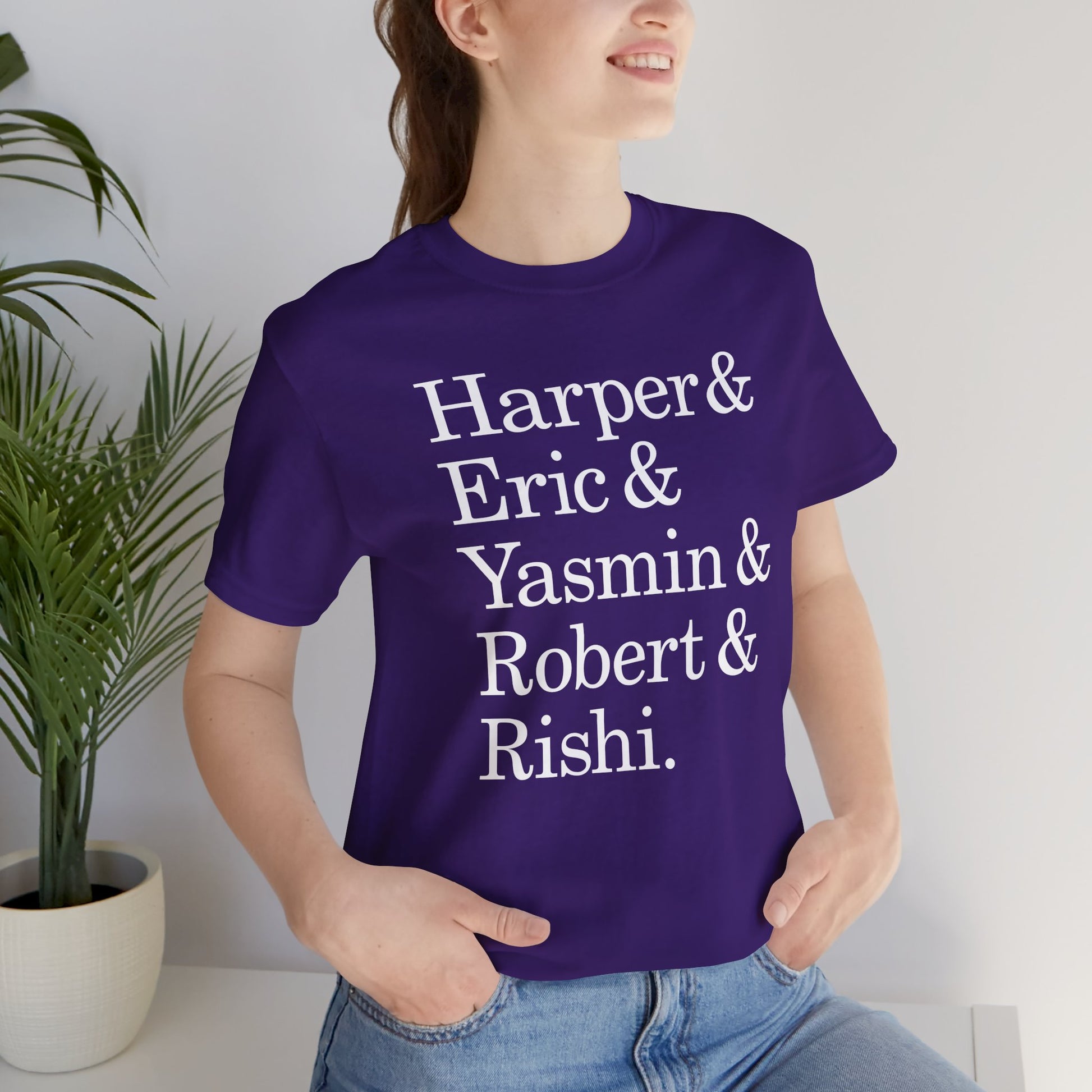 Woman wearing purple t-shirt with names Harper, Eric, Yasmin, Robert & Rishi in Pierpoint & Co. font, inspired by TV show Industry.