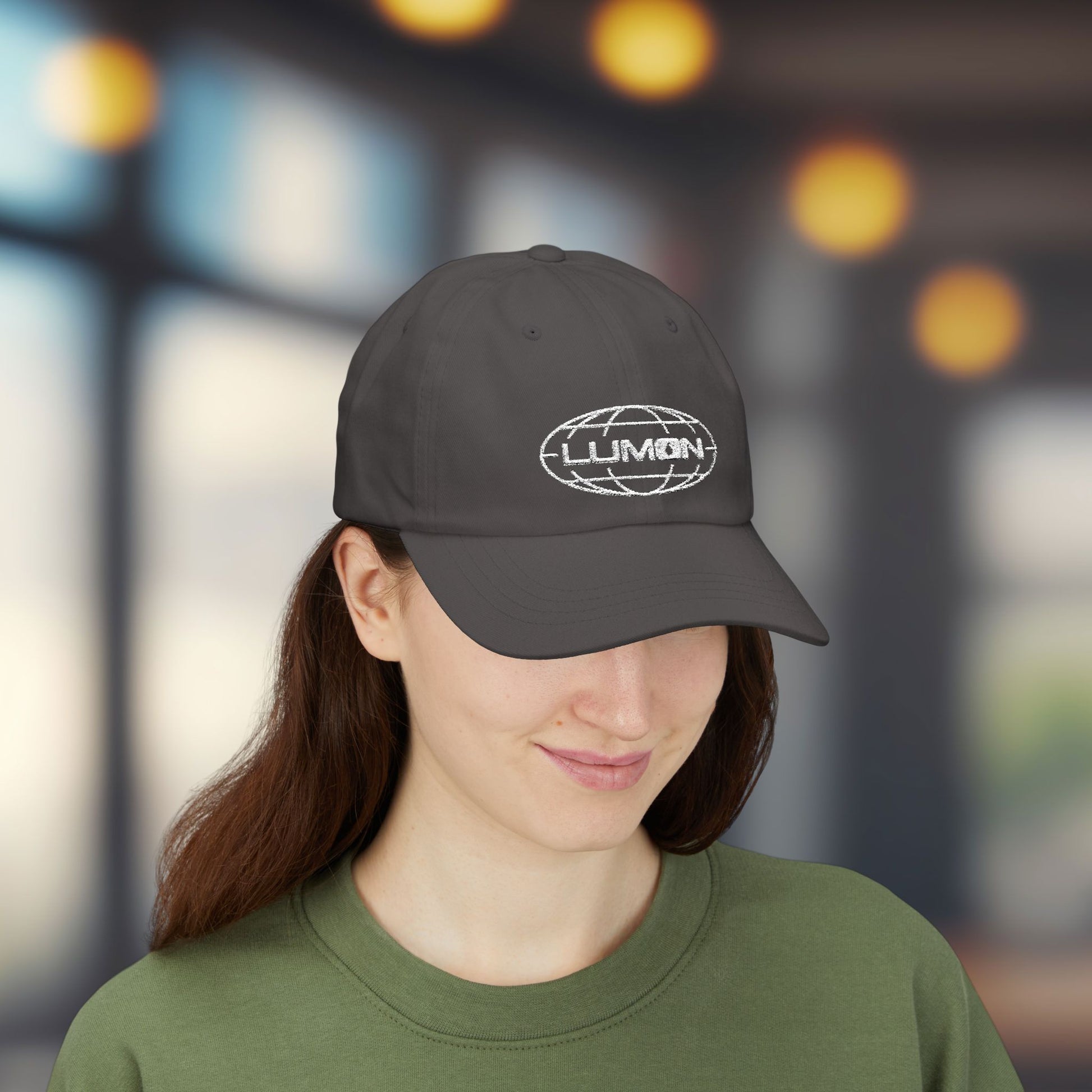 Woman wearing gray dad hat with white embroidered Lumon Industries globe logo, Severance-inspired design cap
