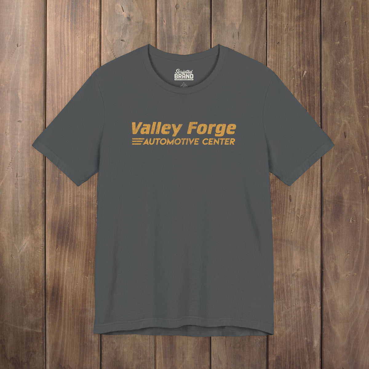Dark gray tee with vintage gold Valley Forge Automotive Center auto shop logo from comedian Shane Gillis Tires TV show