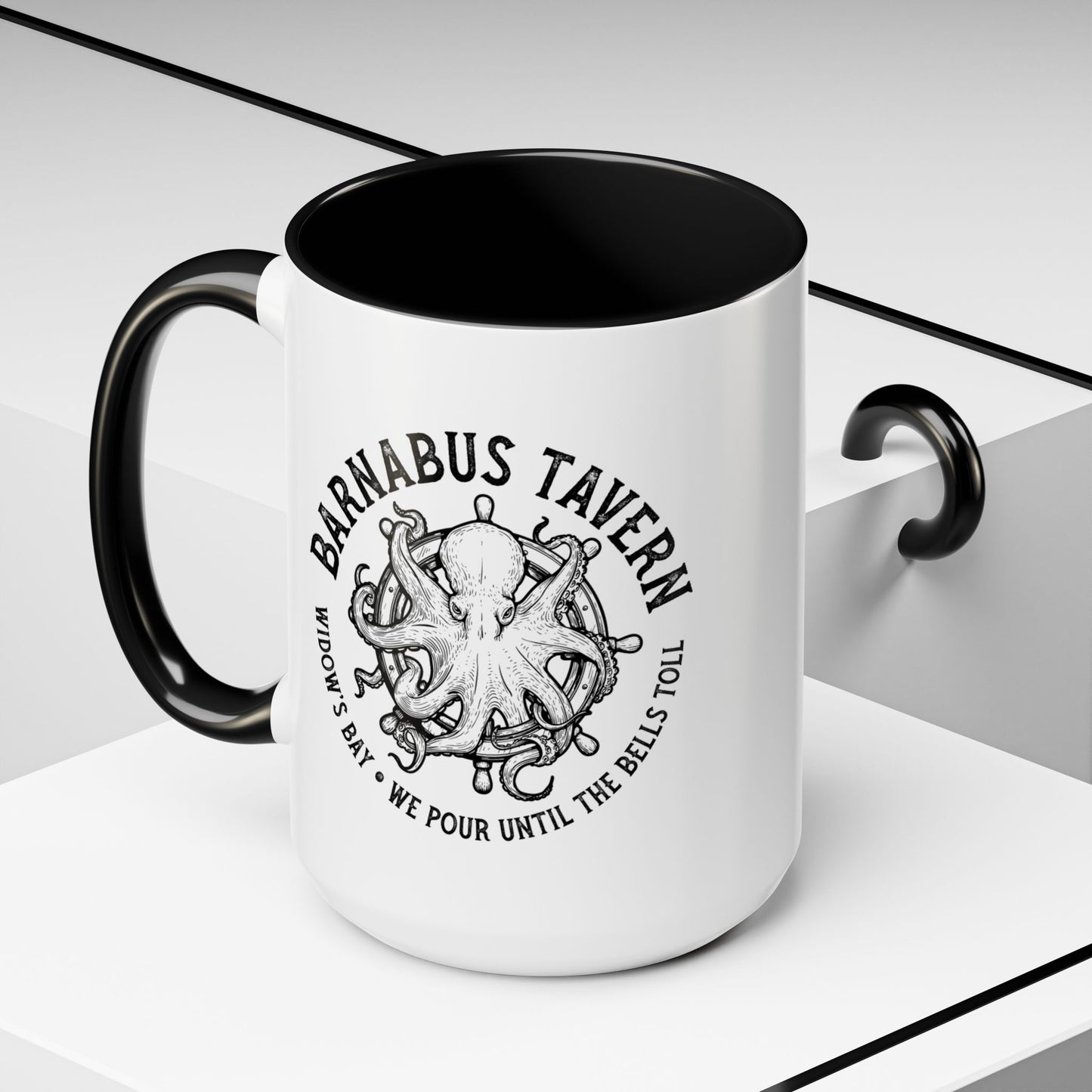 Angled view of 15 oz White accent mug with black handle on left and vintage Barnabus Tavern octopus ship's wheel design inspired by Widow's Bay.