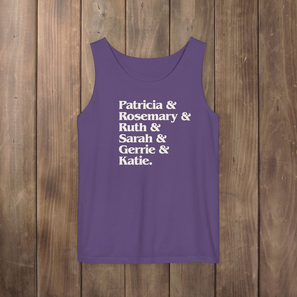 Grape purple garment-dyed Comfort Colors tank top with stacked Women of Widow's Bay show names in ampersand list including Patricia, Ruth, Rosemary