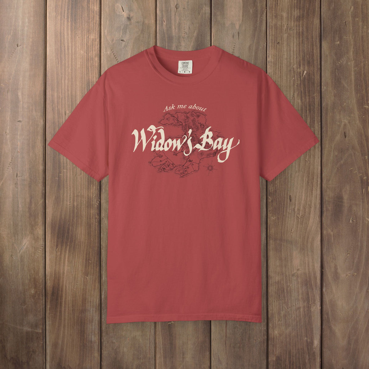 Front of crimson Comfort Colors tee with a vintage island map and antique "Ask Me About Widow's Bay" type from the Apple TV show