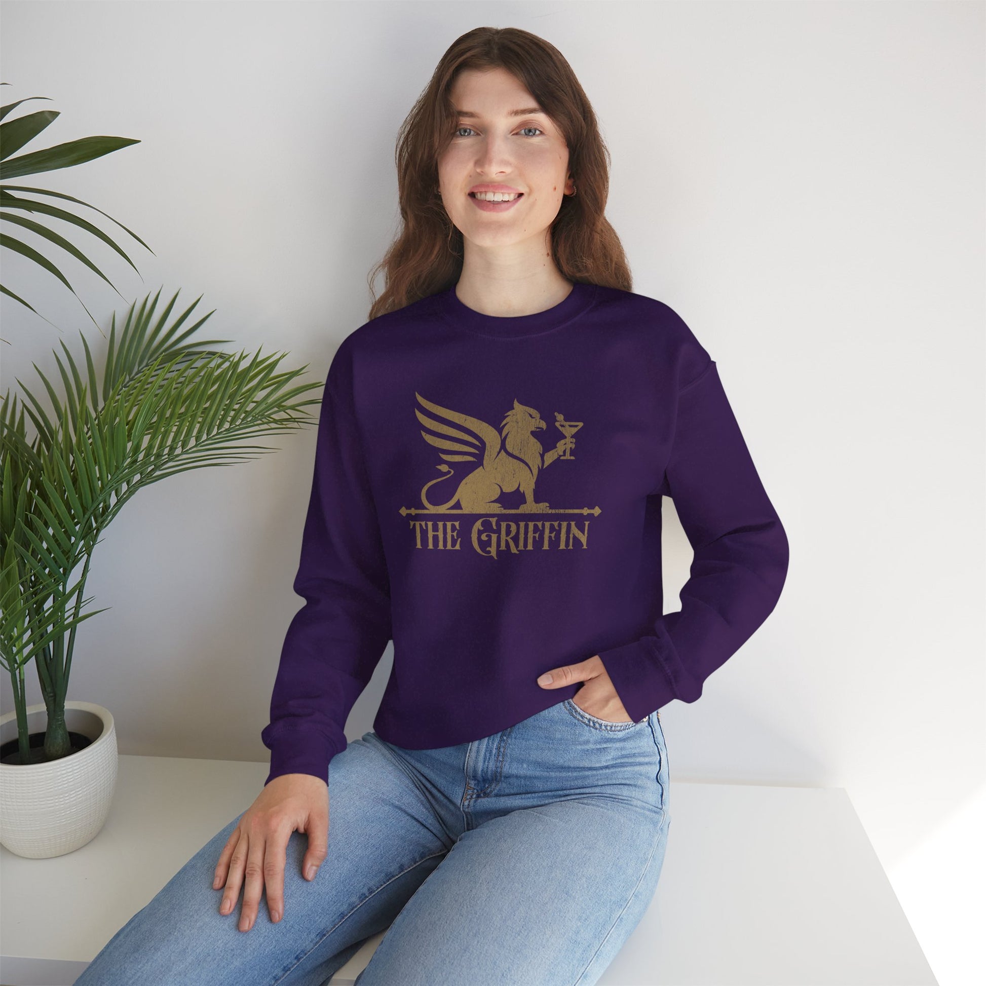Woman wearing purple crewneck sweatshirt with vintage distressed The Griffin Bar logo graphic inspired by New Girl