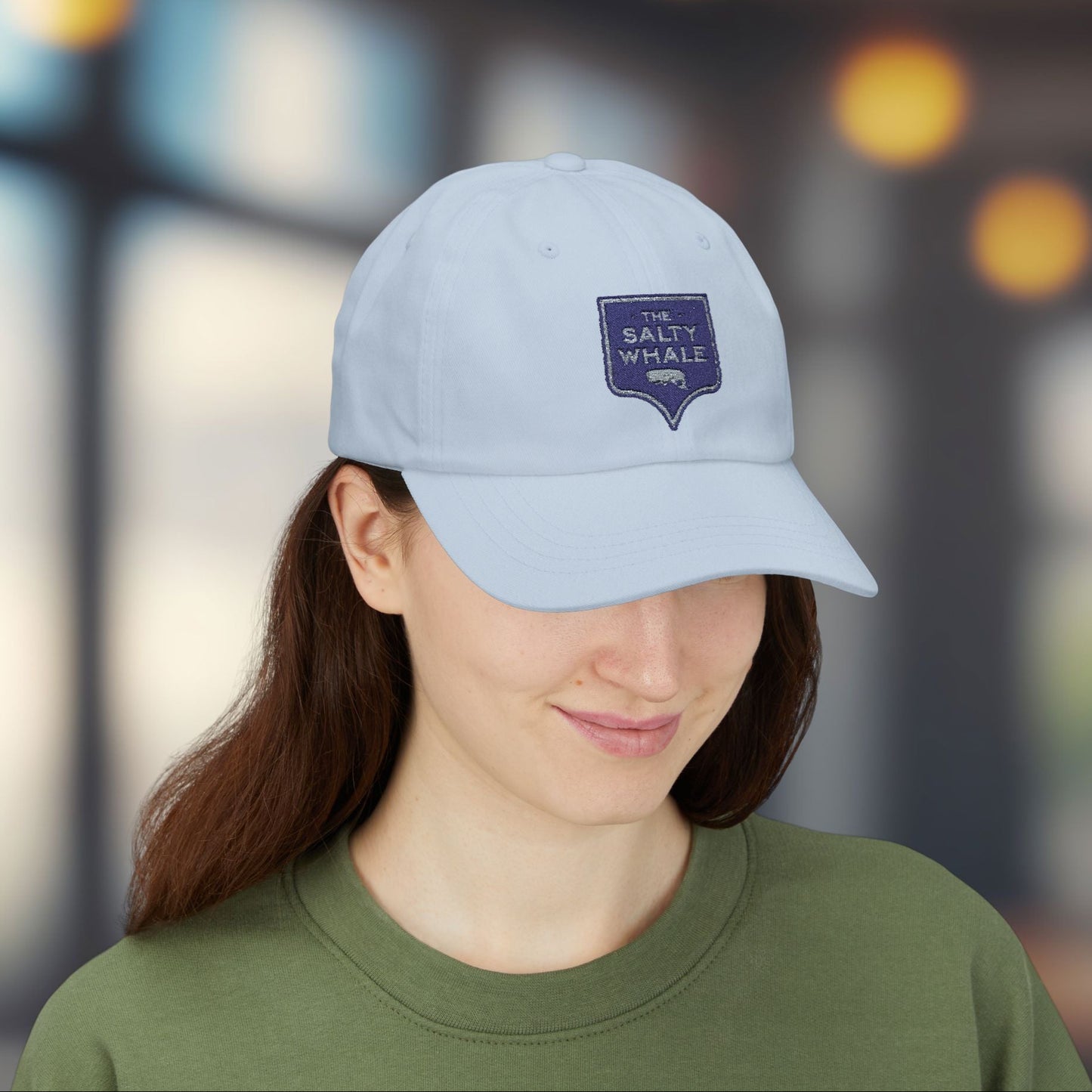 Woman wearing Light blue 'The Salty Whale' embroidered sign logo dad cap inspired by Widow's Bay Apple TV series, 100% cotton baseball hat