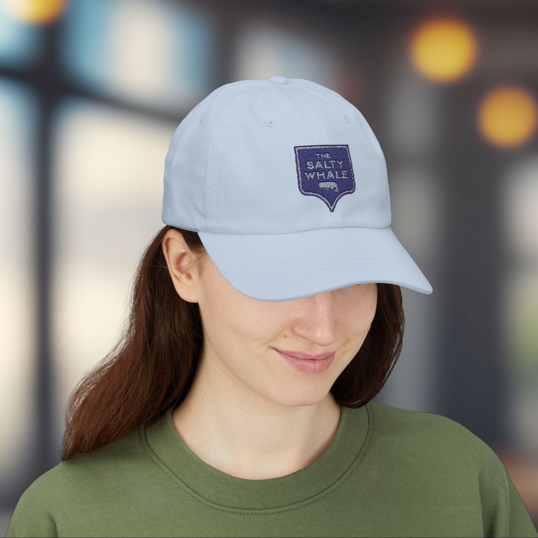 Woman wearing Light blue 'The Salty Whale' embroidered sign logo dad cap inspired by Widow's Bay Apple TV series, 100% cotton baseball hat