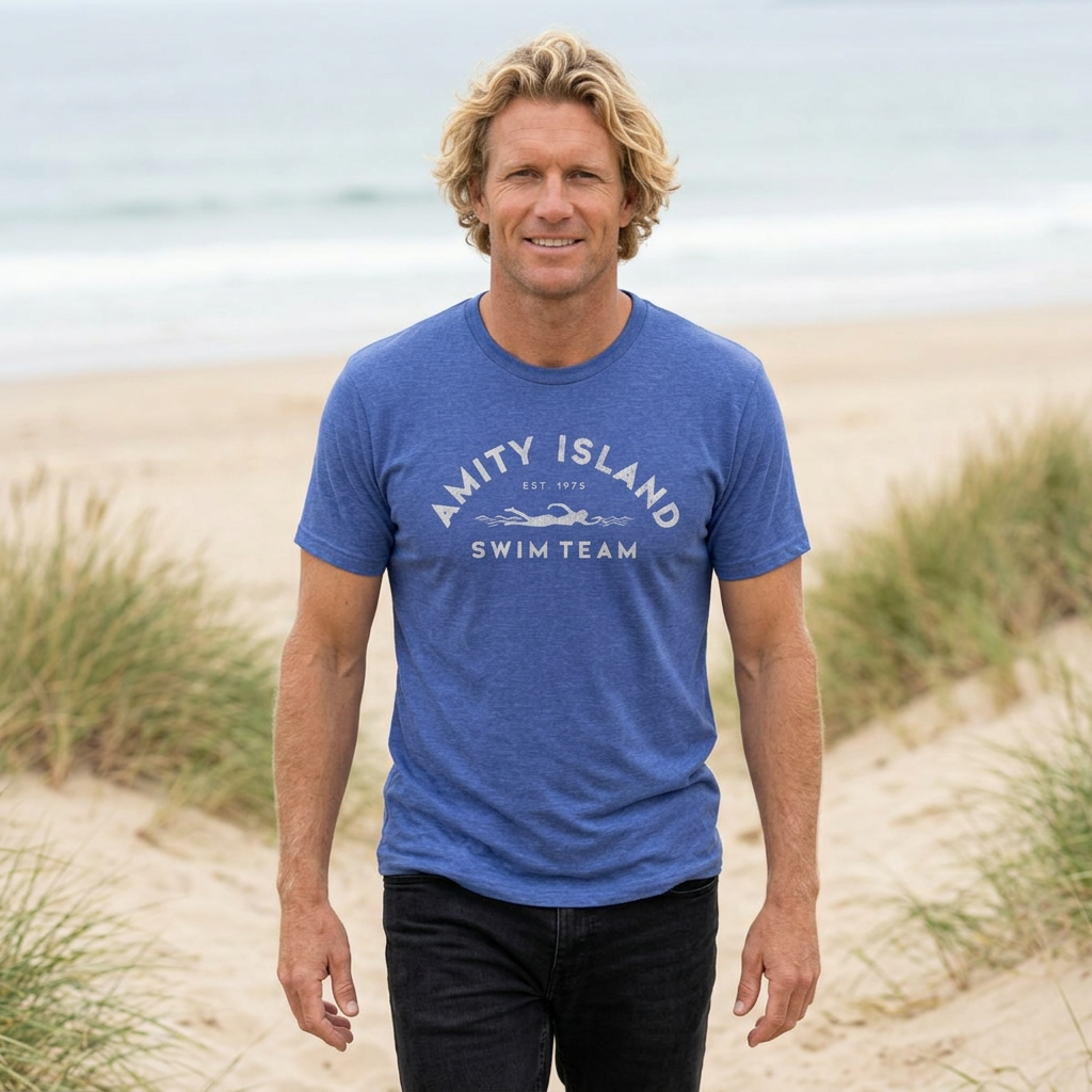 Person wearing Heather Royal Blue tee with vintage distressed Amity Island Swim Team Jaws-inspired swimmer logo