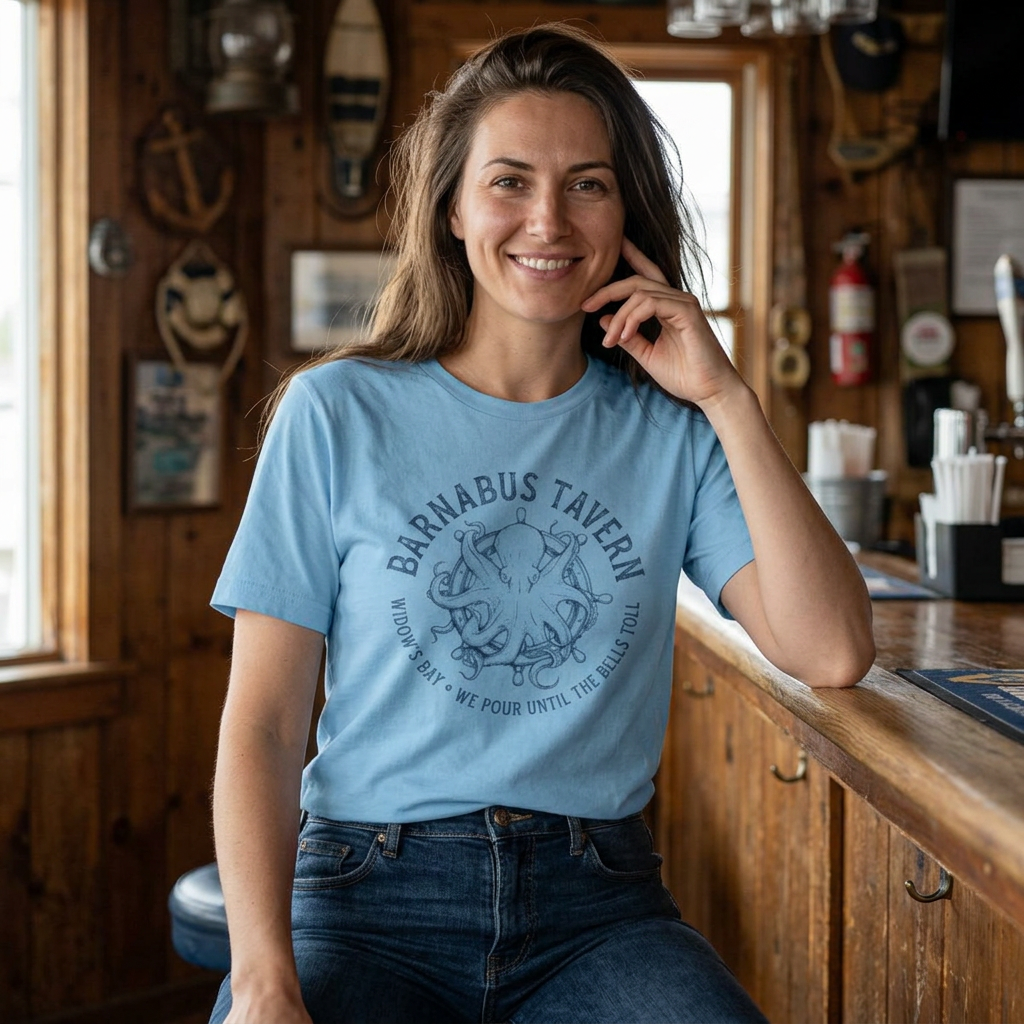 Woman wearing light blue tee with vintage engraved Barnabus Tavern octopus and ship's wheel Widow's Bay design