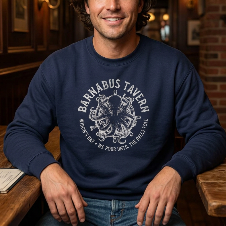 Person wearing navy crewneck sweatshirt with vintage Barnabus Tavern graphic from Widow's Bay TV show octopus design