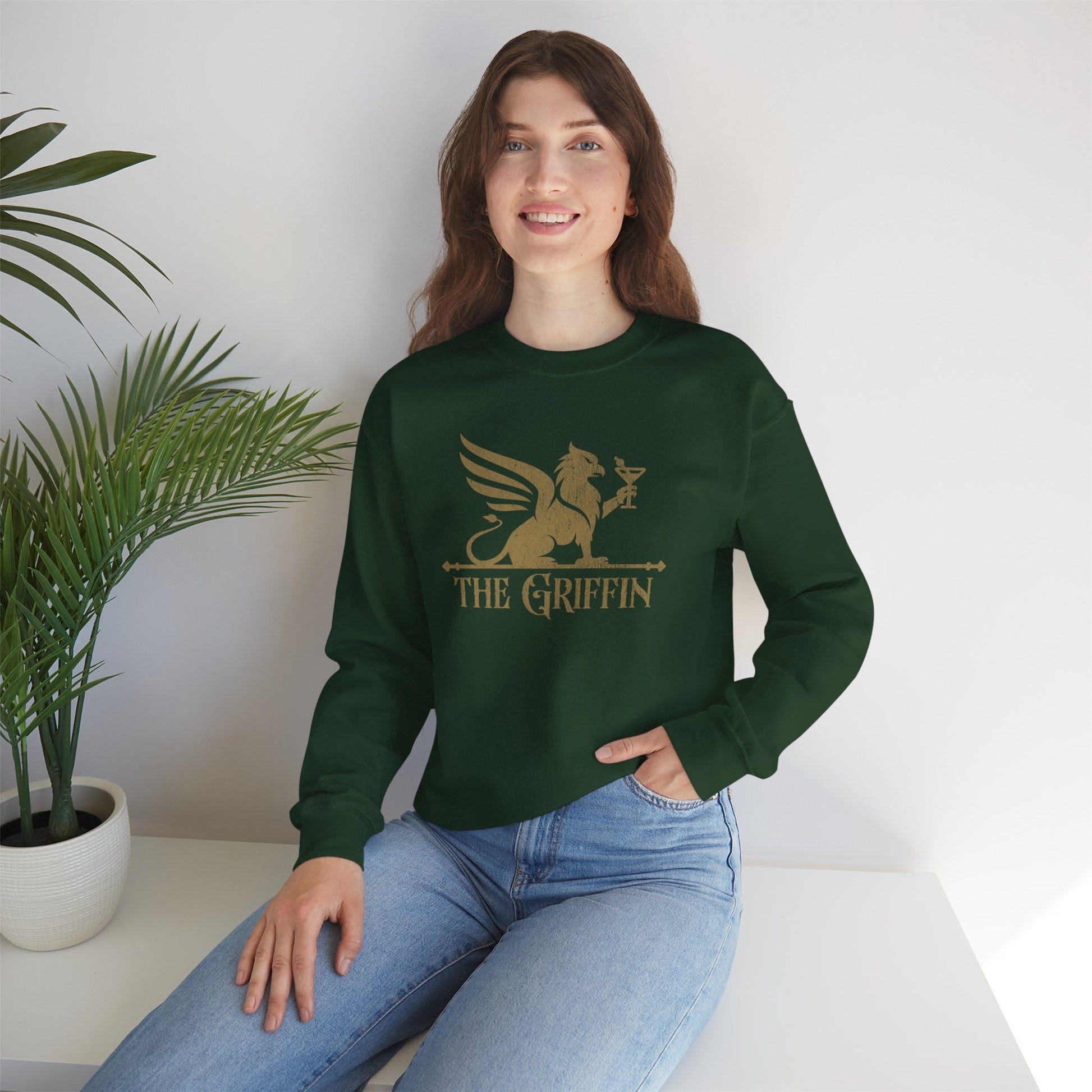 Woman wearing green crewneck sweatshirt with vintage distressed The Griffin Bar logo graphic inspired by New Girl