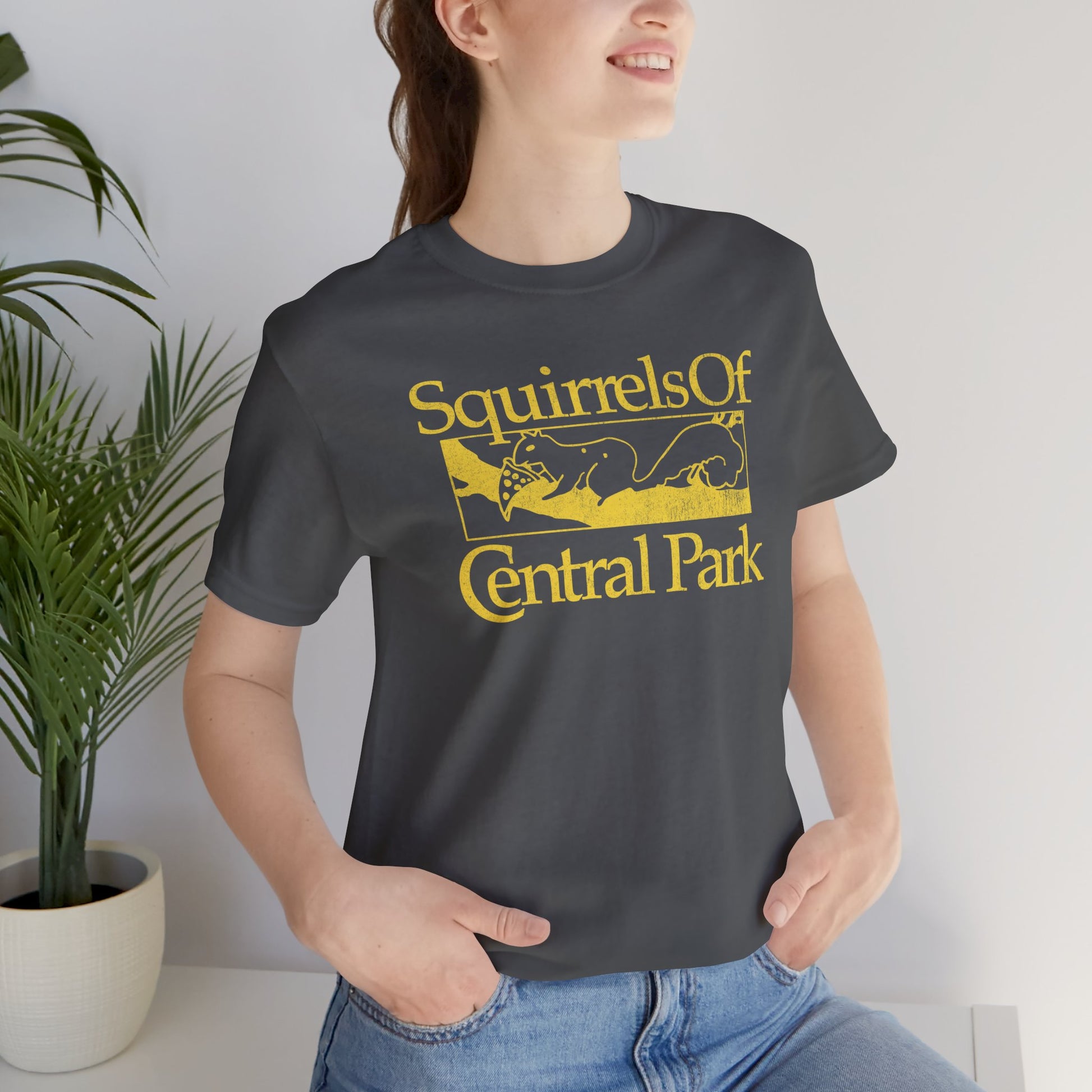 Woman wearing asphalt gray unisex t-shirt with distressed “Squirrels of Central Park” graphic, worn by Eva Garvey in the show Bad Sisters.