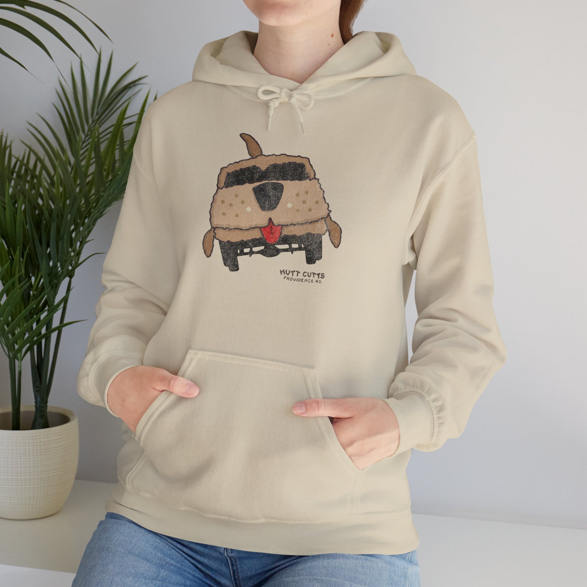 Woman wearing sand beige colored Gildan 18500 hoodie with vintage distressed Mutt Cutts dog van graphic inspired by Dumb and Dumber movie.