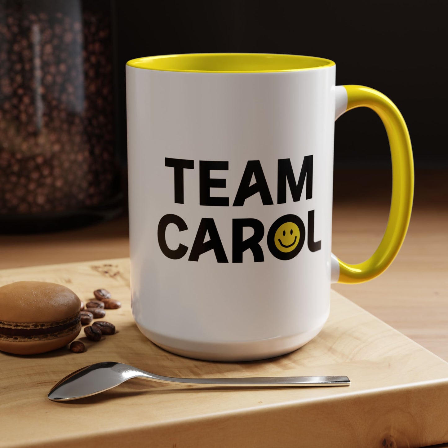 15 oz ceramic accent mug with yellow handle and interior, TEAM CAROL text and smiley face from Pluribus, shown in kitchen